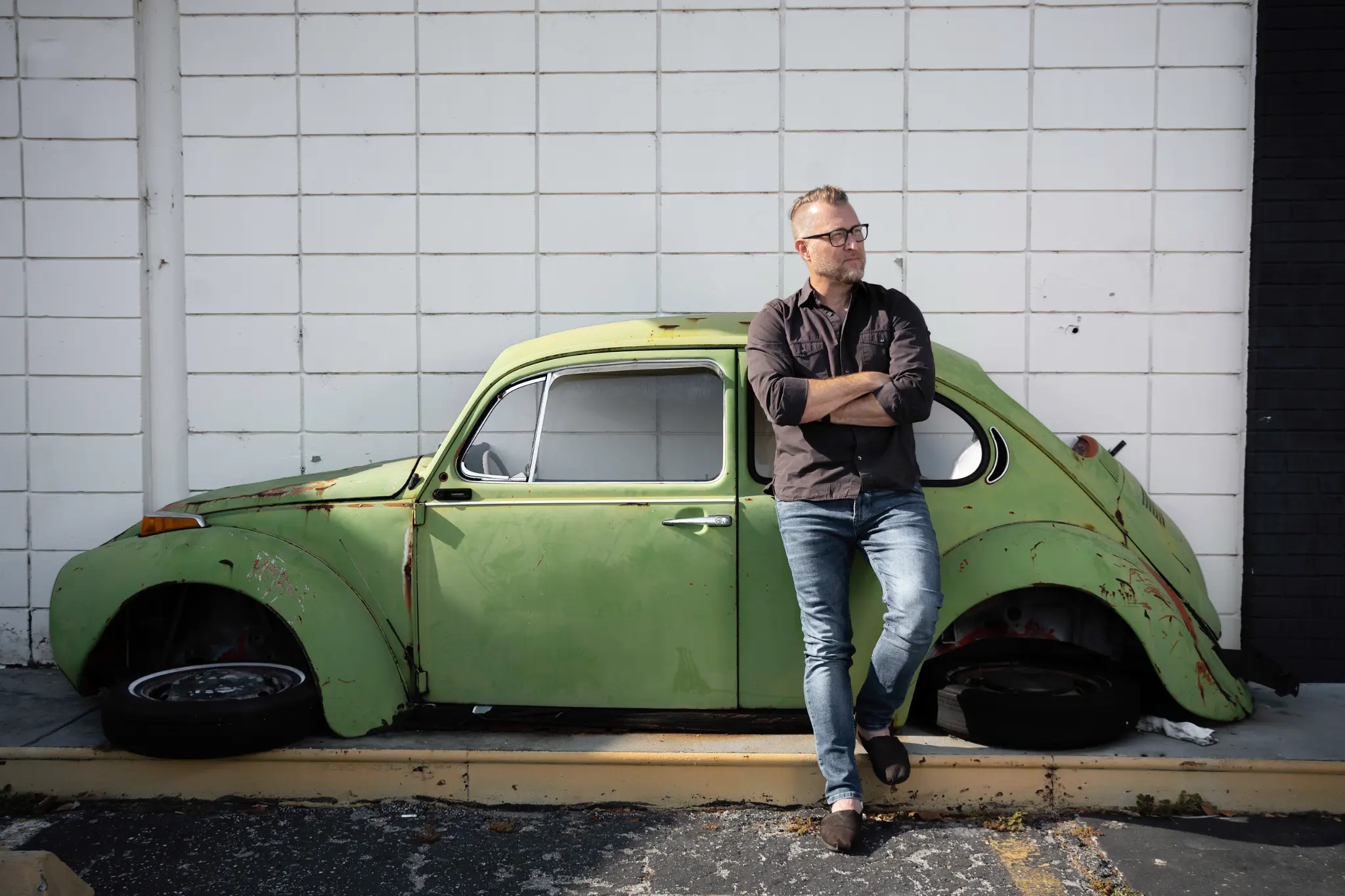 Jason Clark leaning on vintage VW Beetle